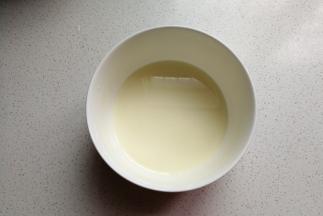 玉米油和牛奶放入容器中，用手动打蛋器搅拌至乳化状态。