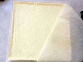 凉透后取出，重新铺一张油纸在蛋糕表层，连蛋糕一起翻转，将表层扣在油纸上，之后揭掉蛋糕底层的油纸