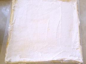 冰箱取出冷藏的淡奶油，在蛋糕表层抹上一层薄薄的淡奶油