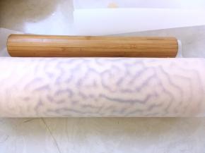 最后再借用擀面杖的力度，推一下油纸，将蛋糕卷卷紧