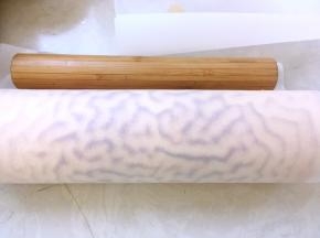 最后再借用擀面杖的力度，推一下油纸，将蛋糕卷卷紧