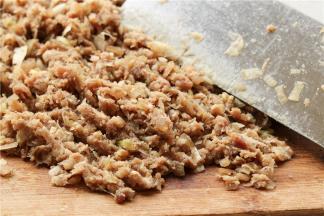 再混入切碎的葱白，用刀背连续的剁肉，最后成为很黏的肉泥。