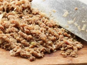 再混入切碎的葱白，用刀背连续的剁肉，最后成为很黏的肉泥。