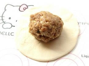 把100克调好的肉馅团成球，放入面皮里。