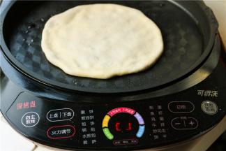 电饼铛预热，刷一层油，放入肉饼胚子，开始烙饼。