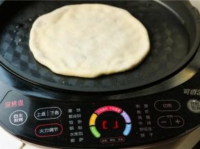 电饼铛预热，刷一层油，放入肉饼胚子，开始烙饼。