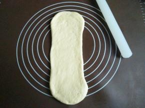 再次把面团擀长，自上而下卷起来