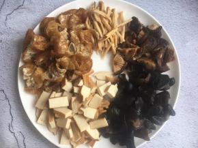 面筋切成小块，香干切成小块，木耳撕成小片，香菇切成小块，花菜切成寸段。