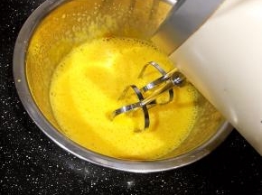 蛋黄加入50克糖，隔热水打发，蛋黄糊38度左右离火，继续打发至粘稠。