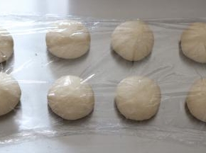 将分好的面团滚圆，盖上保鲜膜静置15分钟左右