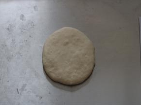 用掌根拍掉面团中大气泡，做排气处理