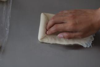 自上而下用手指将面团自然卷起，收口