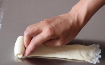 自上而下用手指将面团自然卷起，收口