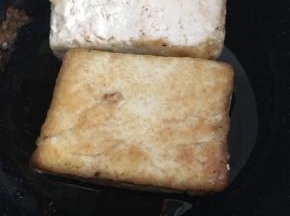 豆腐均匀的抹上淀粉，放锅里煎至两面金黄。