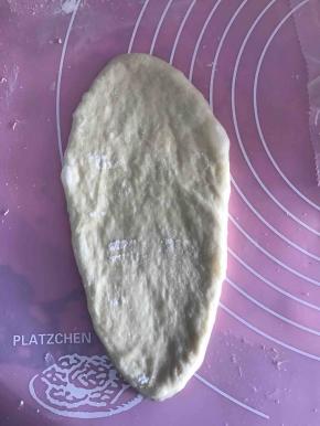 松弛好后，取一个面团幹开，然后翻面，从上往下卷起，收口捏紧。