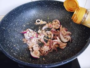 起油锅，加入洋葱煸炒，再加入腌制好的鱿鱼圈，加入生抽。