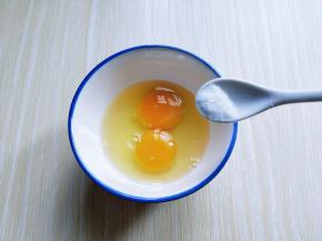 将鸡蛋敲入碗中，加入盐。