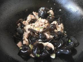 放入木耳，煸炒片刻。