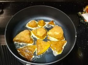 锅里烧热加油，把裹了蛋液的粽子放入油锅里
