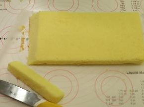 将方形的蛋糕片平均切成两片，取其中一片的一个边斜切（如图）