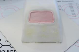 白色翻糖膏加一点点红色色素，调成粉色，做出车窗，车头位置抹少许奶油霜