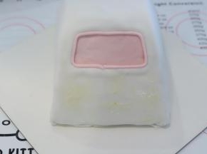 白色翻糖膏加一点点红色色素，调成粉色，做出车窗，车头位置抹少许奶油霜