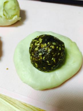 擀成圆形，放馅儿料，包好。