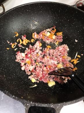 加入肉碎继续翻炒。
