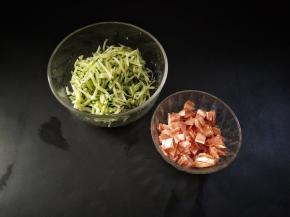 黄瓜擦丝加入少许的盐将其腌出汁水。培根切成小片，放入锅里面煸至微黄盛出备用