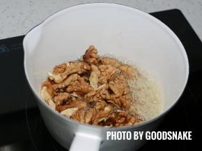 关火，倒入核桃，用刮刀搅拌，使核桃均匀的挂上糖糊