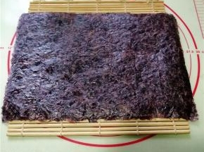 取一寿司帘，放上一张海苔