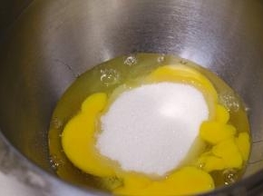 鸡蛋打散加入细砂糖。烤箱165度预热