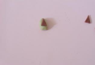 将红色小三角粘在原色三角面团上。