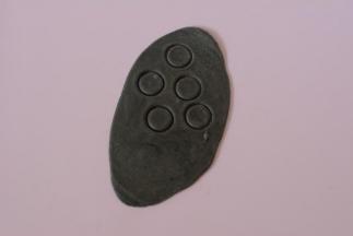 浅黑色面团擀开，压出大小合适的圆形面片5个。