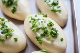 取出的面团先刷一遍薄薄的全蛋液后，再洒上拌好的葱花