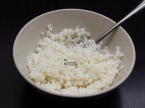 浸泡好的大米，用淘米篮把水沥干，放入一个碗里，放盐、油拌均。