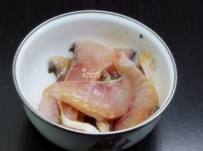 等待煮粥的时候，把鱼肉切薄块，放盐、油、生抽、生粉、生姜丝拌均腌制。