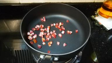 炒锅烧热油，放入腊肠翻炒。