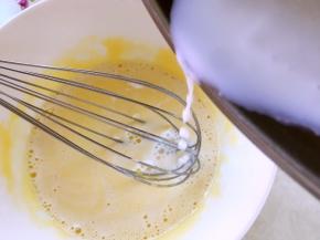 将热牛奶一点点加入到蛋黄糊中，边加入边搅拌，直到将牛奶全部加进来