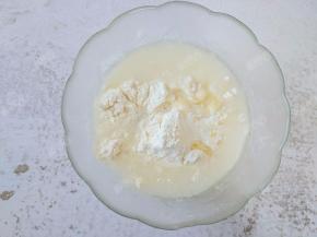 先做油皮面团。将200g面粉和20g油放入大碗中，倒入120g热水，边倒边用筷子搅拌