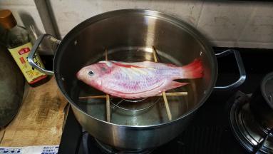 把鱼放在筷子上，盖上锅盖大火蒸8分钟
