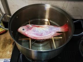 把鱼放在筷子上，盖上锅盖大火蒸8分钟