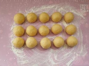 再把面团分成约50克一份，搓圆，手上要抹一点面粉防粘，盖上保鲜膜让它松弛十分钟。