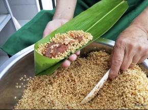 顶部折一个漏斗的样子，铺一层糯米，中间加猪肉馅，再铺米盖住馅料，包之前稍微抖一抖，把周围多余的糯米抖掉。