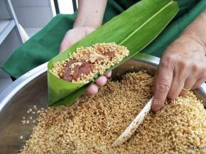 顶部折一个漏斗的样子，铺一层糯米，中间加猪肉馅，再铺米盖住馅料，包之前稍微抖一抖，把周围多余的糯米抖掉。