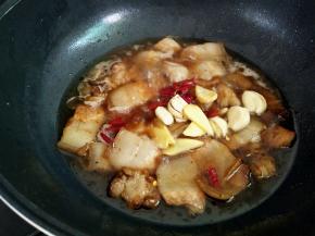 加入一小碗的热水，下干辣椒段，蒜子，姜片，盖上盖子小火闷煮个15分钟。