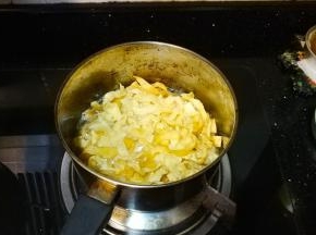 锅里放入宽油，放入云吞皮条炸至金黄色