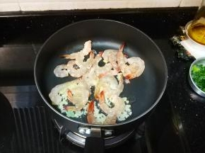 锅里放入蒜蓉、姜蓉、虾仁翻炒