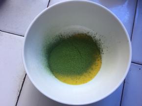 搅拌好的蛋黄糊，分一点出来，筛入1克抹茶粉搅拌均匀