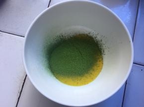 搅拌好的蛋黄糊，分一点出来，筛入1克抹茶粉搅拌均匀
